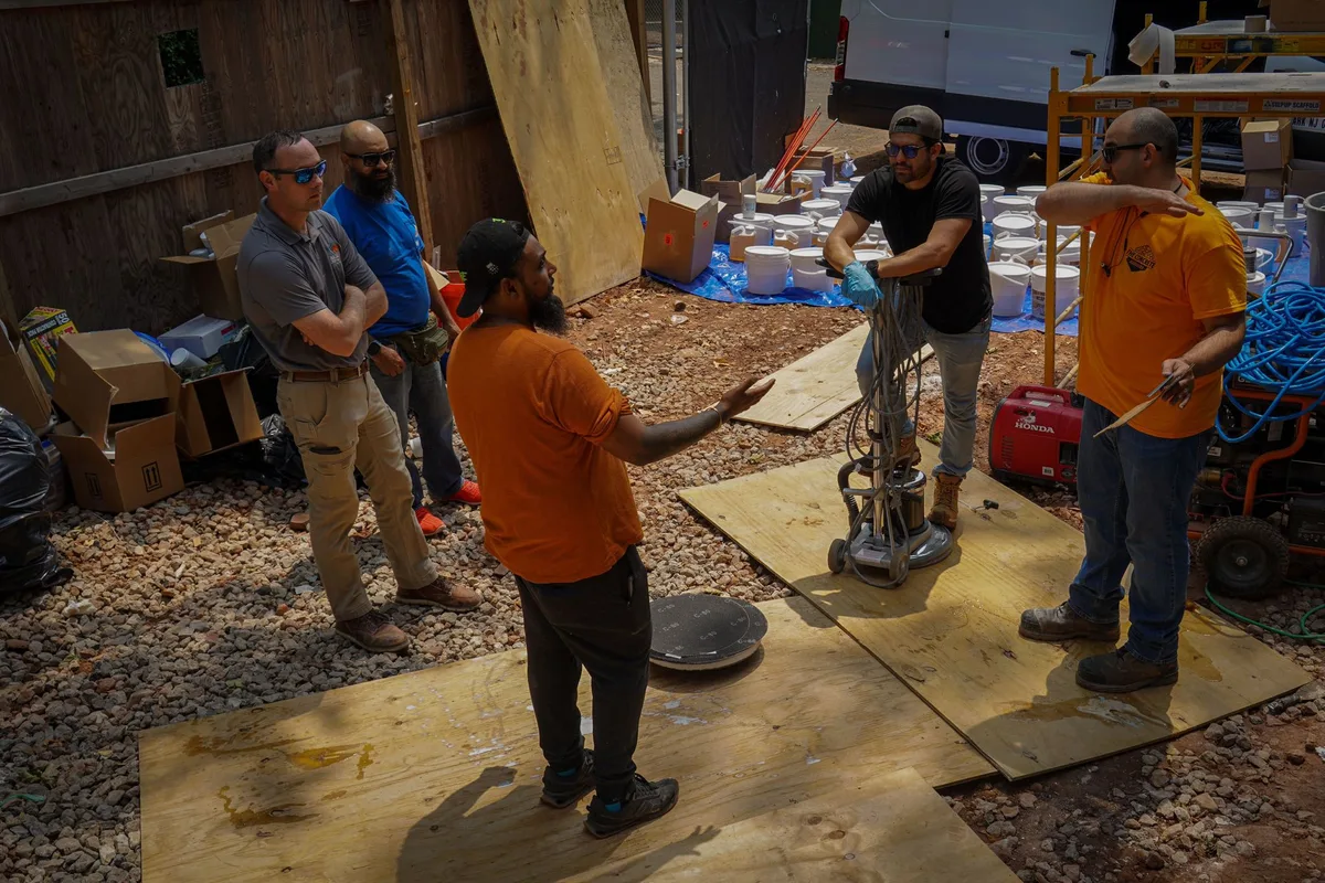 Training class crew discussing techniques on a live job site